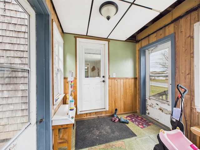 interior space featuring wainscoting, wood walls, and baseboards