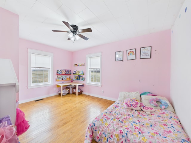 bedroom featuring visible vents, wood finished floors, ceiling fan, and multiple windows