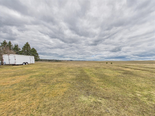 view of yard with an outbuilding, an outdoor structure, and a rural view