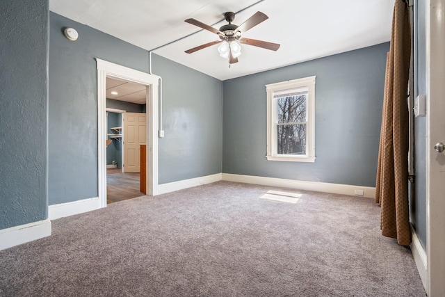 unfurnished bedroom with baseboards, a ceiling fan, and carpet flooring