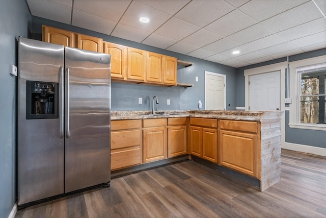 kitchen with stainless steel fridge with ice dispenser, a sink, baseboards, a peninsula, and dark wood-style flooring