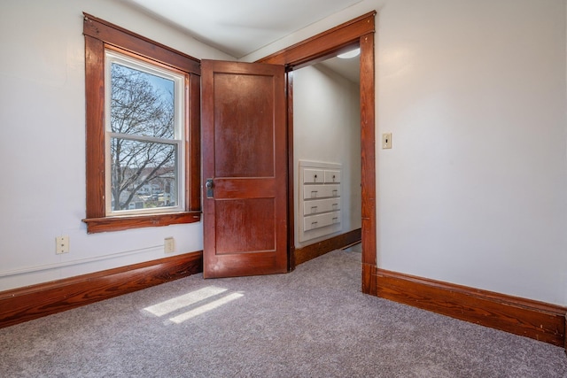 interior space featuring plenty of natural light, carpet flooring, and baseboards