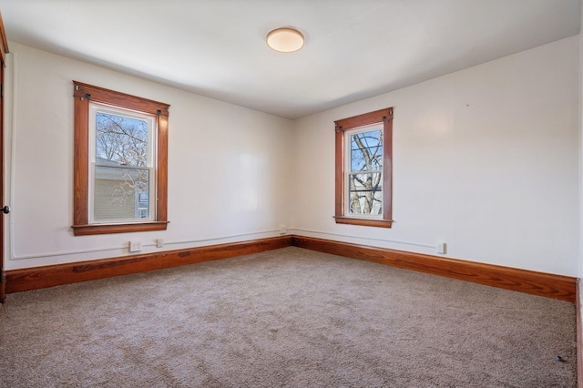 carpeted spare room featuring baseboards