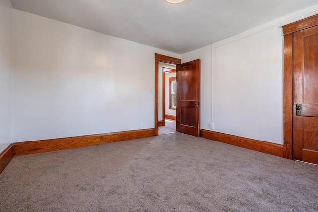 carpeted empty room featuring baseboards