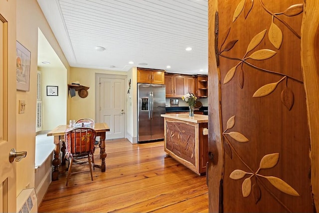 kitchen featuring light wood-style flooring, light countertops, recessed lighting, stainless steel refrigerator with ice dispenser, and brown cabinetry