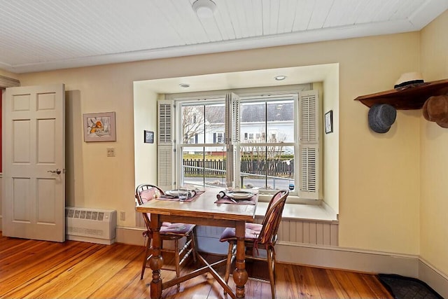 dining room with hardwood / wood-style floors and radiator heating unit