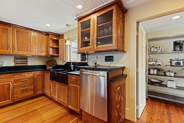kitchen with stainless steel dishwasher, a sink, light wood-style flooring, and brown cabinetry