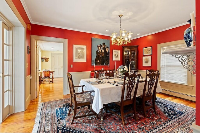 dining space with crown molding, a notable chandelier, baseboard heating, and light wood-type flooring