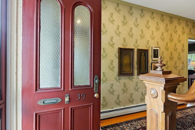 view of exterior entry with a baseboard heating unit