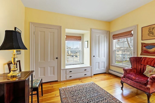 sitting room featuring light wood-style floors and a baseboard radiator