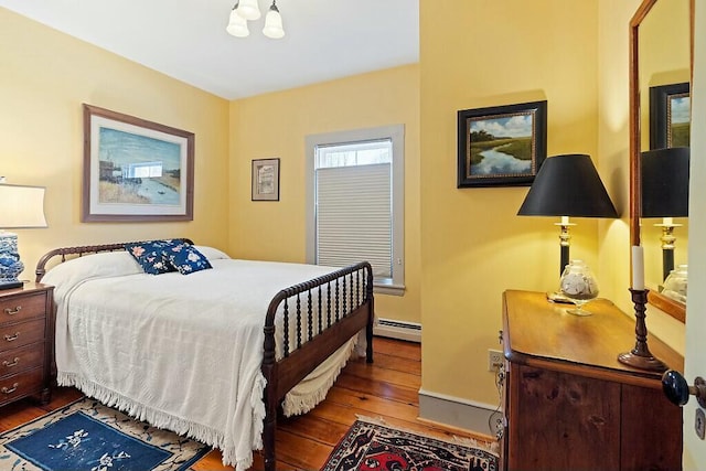 bedroom featuring hardwood / wood-style floors and baseboard heating
