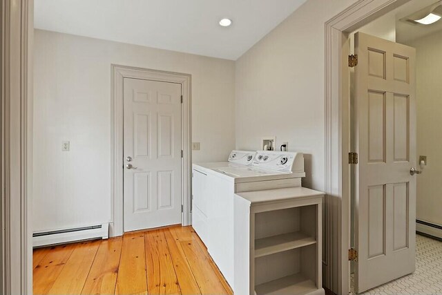 clothes washing area featuring recessed lighting, washing machine and clothes dryer, laundry area, light wood-type flooring, and baseboard heating