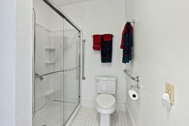 bathroom featuring baseboards, a stall shower, tile patterned floors, and toilet