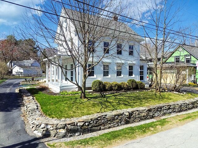 view of front facade featuring a front lawn and a chimney