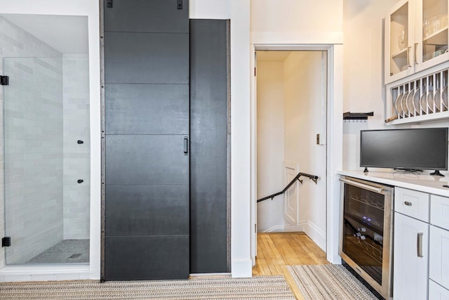interior space with baseboards, light wood-type flooring, and beverage cooler