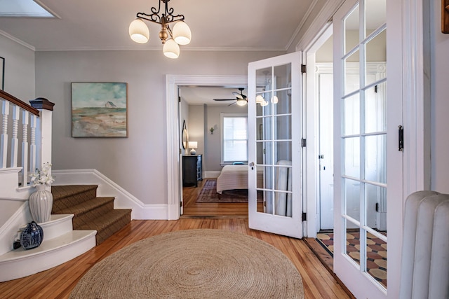 foyer featuring crown molding, stairs, baseboards, radiator heating unit, and light wood-style flooring
