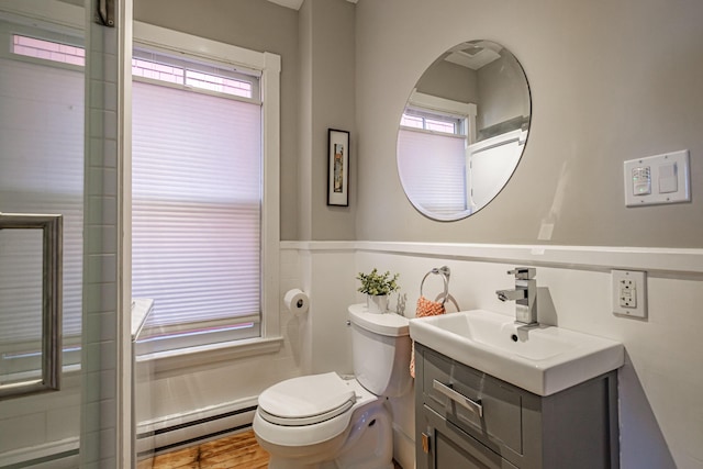 bathroom with toilet, a baseboard heating unit, a wealth of natural light, and vanity