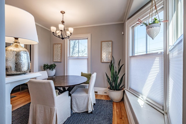 dining room featuring crown molding, baseboards, a chandelier, and wood finished floors