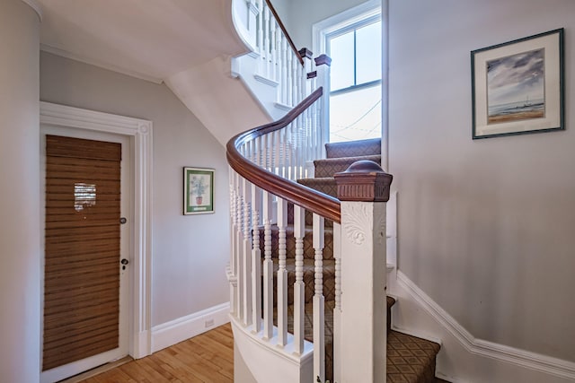 stairway with baseboards and wood finished floors