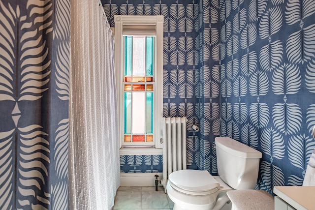 bathroom featuring baseboards, toilet, marble finish floor, radiator, and wallpapered walls