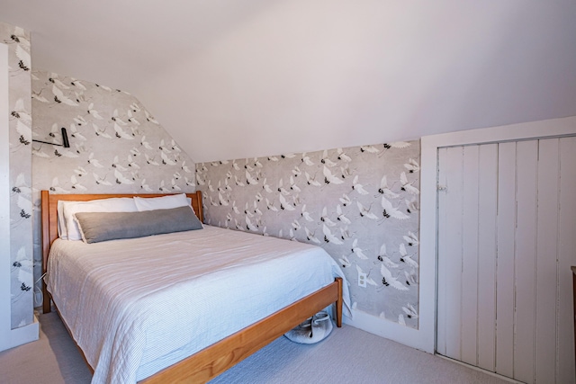 bedroom with carpet floors and vaulted ceiling