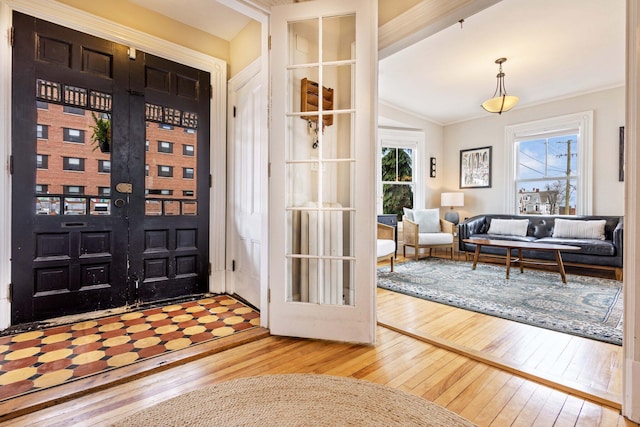 entryway featuring crown molding, vaulted ceiling, and hardwood / wood-style floors
