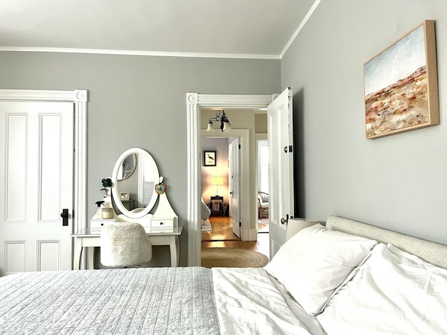 bedroom featuring ornamental molding and wood finished floors