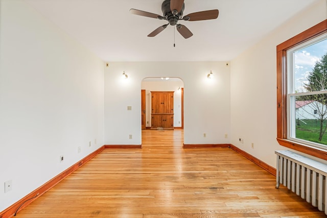 30 Munroe St, Bangor, ME 04401 - empty room featuring radiator heating unit, light wood-style floors, baseboards, and ceiling fan