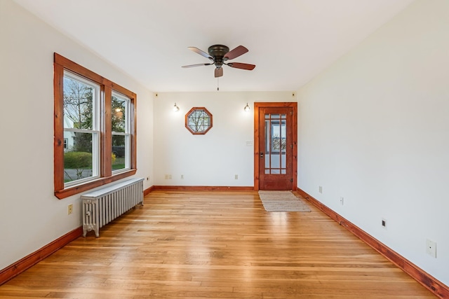 30 Munroe St, Bangor, ME 04401 - unfurnished room with radiator heating unit, plenty of natural light, a ceiling fan, and light wood-style flooring