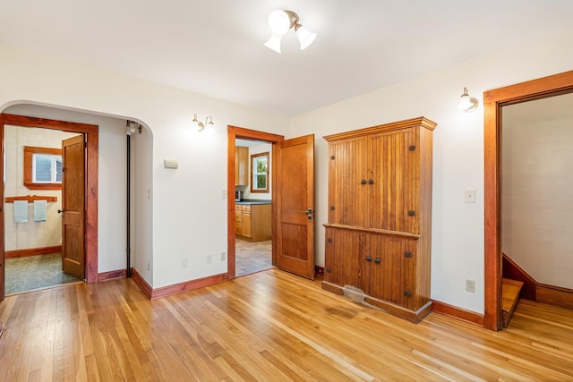 30 Munroe St, Bangor, ME 04401 - unfurnished bedroom with arched walkways, light wood-style flooring, and baseboards
