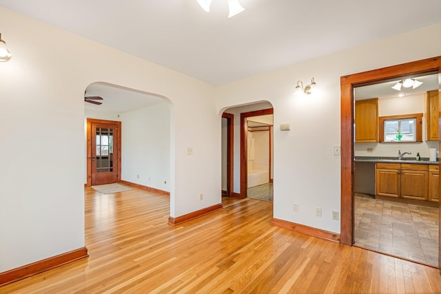 30 Munroe St, Bangor, ME 04401 - spare room with arched walkways, light wood-type flooring, baseboards, a sink, and ceiling fan