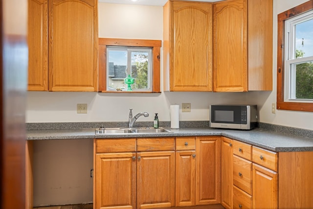 30 Munroe St, Bangor, ME 04401 - kitchen with stainless steel microwave, a sink, dark countertops, and brown cabinetry