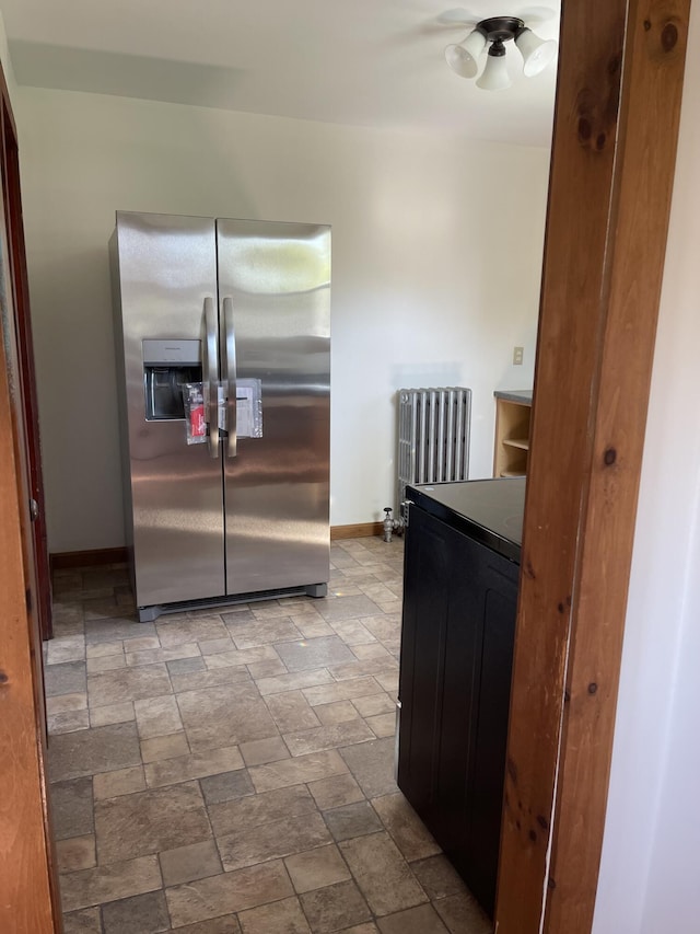 30 Munroe St, Bangor, ME 04401 - kitchen featuring stainless steel fridge with ice dispenser, radiator, baseboards, stone finish floors, and dark countertops
