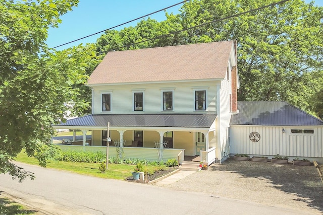 farmhouse-style home with a porch and driveway