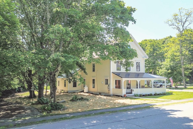 view of front of home with a porch, a standing seam roof, and metal roof
