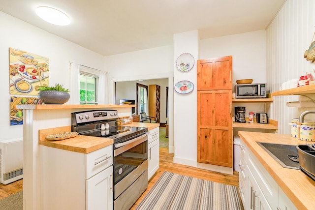 kitchen with white cabinetry, appliances with stainless steel finishes, butcher block counters, and light wood finished floors