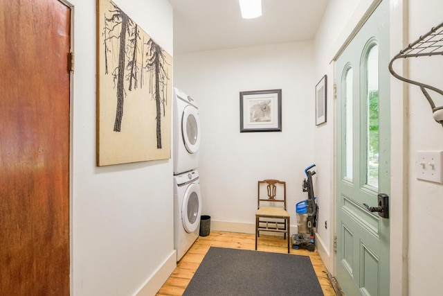 laundry room featuring stacked washer and clothes dryer, light wood finished floors, and laundry area