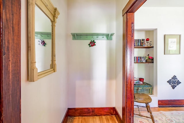 hall featuring wood finished floors and baseboards