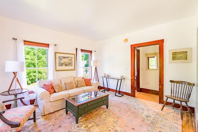 living room with light wood finished floors, baseboards, and a healthy amount of sunlight