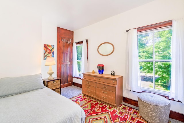 bedroom featuring baseboards and multiple windows