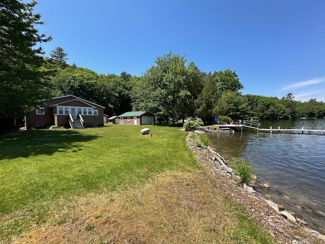 view of yard with a wooded view, a dock, and a water view