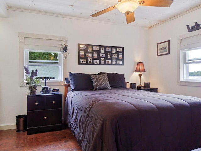 bedroom with a ceiling fan, ornamental molding, and dark wood finished floors