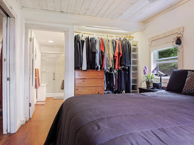bedroom featuring wooden ceiling, wood finished floors, a closet, and ensuite bathroom
