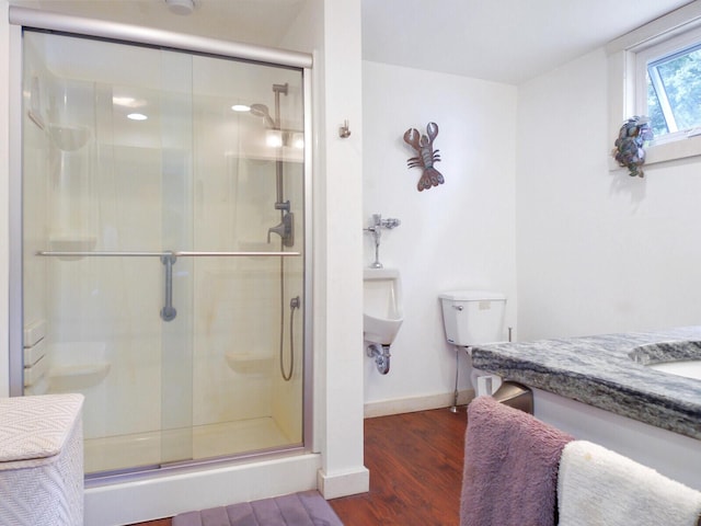 full bath featuring wood finished floors, a shower stall, and baseboards