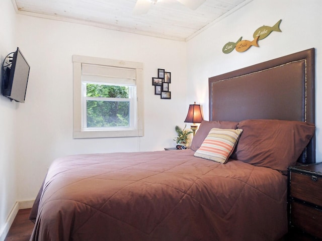 bedroom with a ceiling fan, wood finished floors, and baseboards