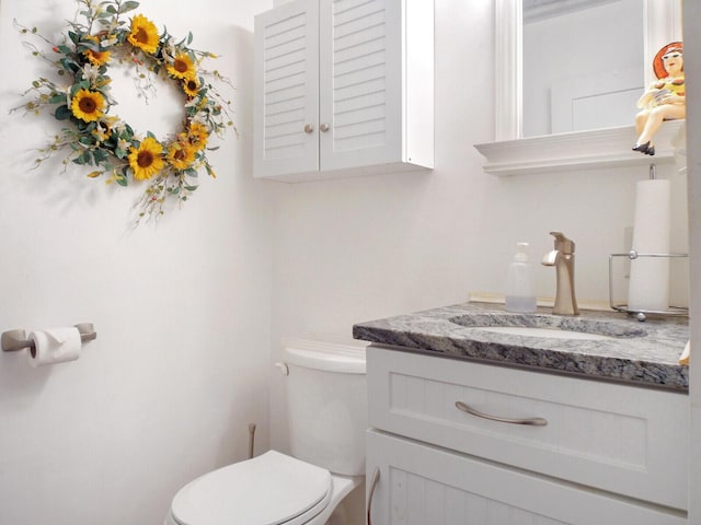 half bathroom featuring vanity and toilet