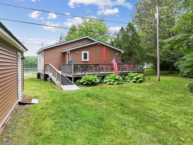 back of property with a yard and a wooden deck
