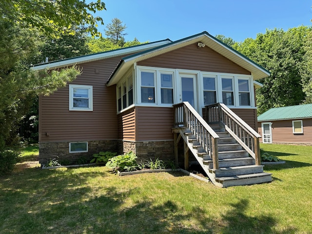 rear view of house featuring a yard