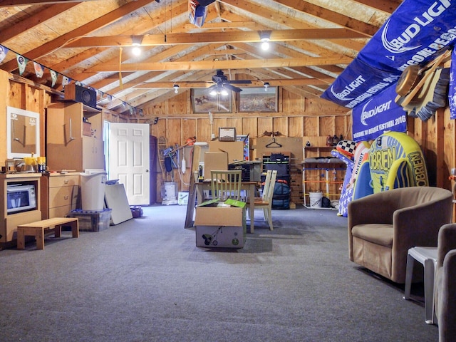 garage with a ceiling fan and wood walls