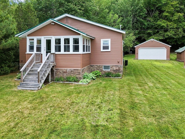 view of front of property featuring a detached garage, an outbuilding, a wooded view, and a front yard